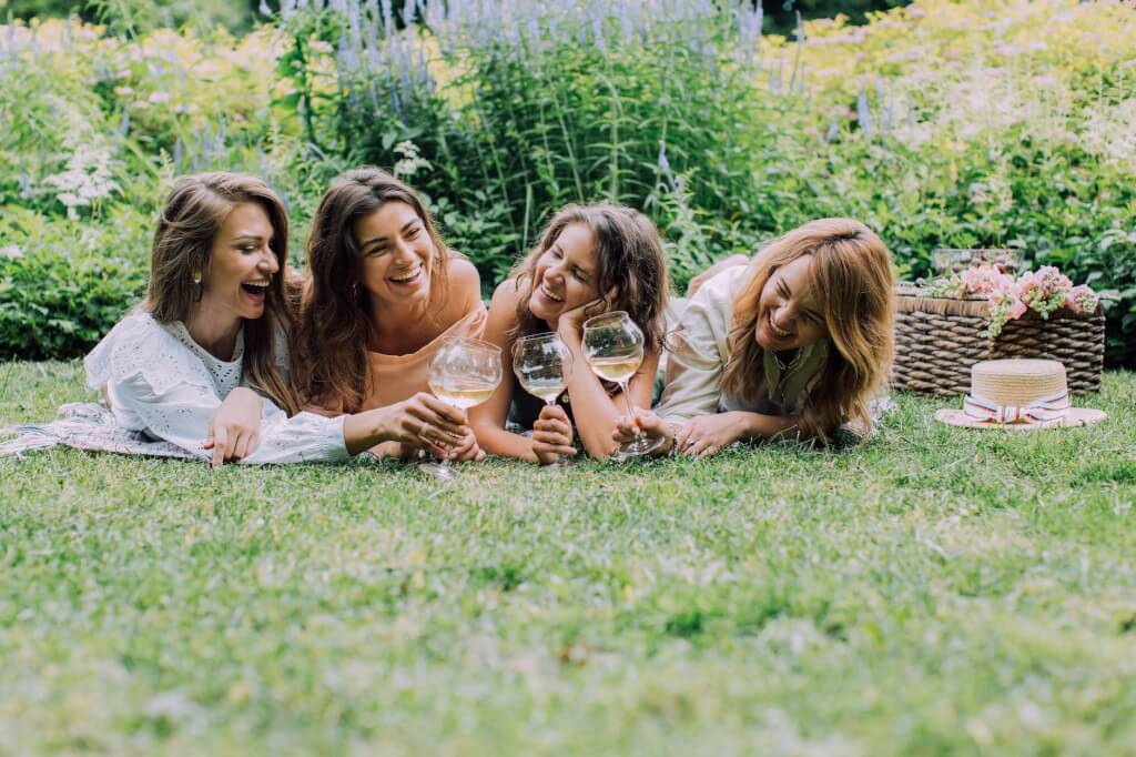 photo of friends doing a toast while lying on the ground